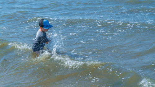 High angle view of boy enjoying in sea