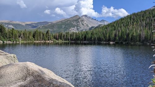 Scenic view of lake by mountains against sky