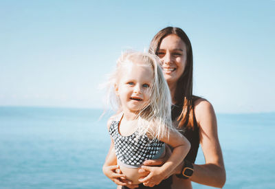 Portrait of a smiling young woman against sea