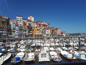 Boats moored at harbor against buildings in city