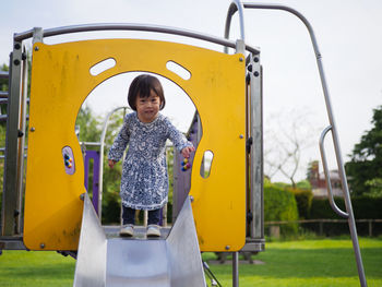 Full length of cute girl on slide in playground