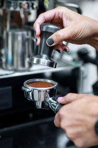 Cropped hand of man preparing coffee