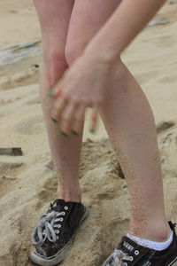 Low section of man standing on beach