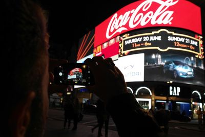 Woman standing in illuminated city at night