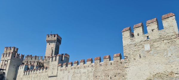 Low angle view of old building against clear blue sky