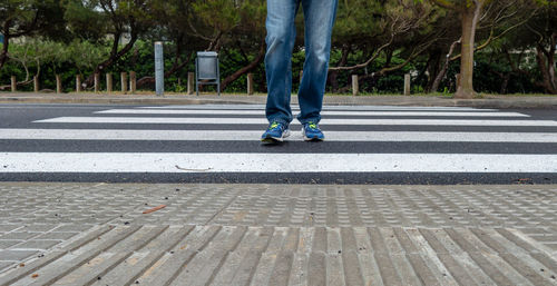 Low section of person walking on crosswalk