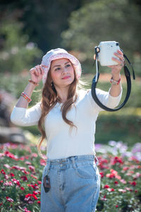 Portrait of smiling woman standing against plants