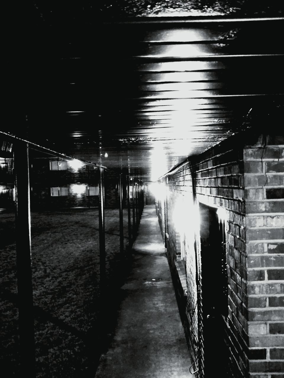 EMPTY FOOTPATH AMIDST ILLUMINATED BUILDINGS IN CITY