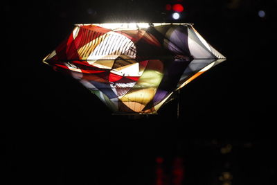 Close-up of illuminated lighting equipment against black background