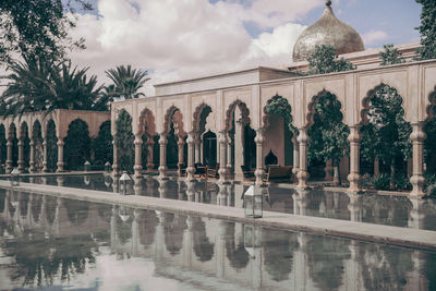 Reflection of trees in swimming pool against building