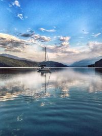 Sailboat sailing on lake against sky