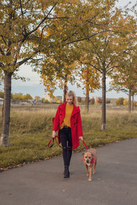 Full length of young woman with dog in park
