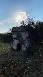 Abandoned house on field against sky