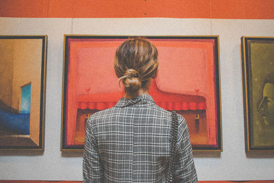 Rear view of woman standing against wall