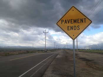 Road sign against sky