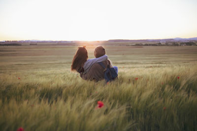 Two women holding hands at sunset in the field