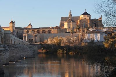 View of old building by river against sky