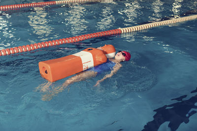 Girl with cpr dummy swimming in pool