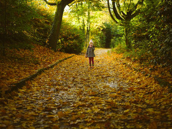Full length of young girl walking on footpath during autumn