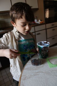 Boy looking away while sitting on table