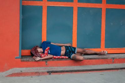 Low section of man sitting on wall