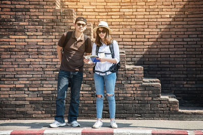 Woman standing against brick wall