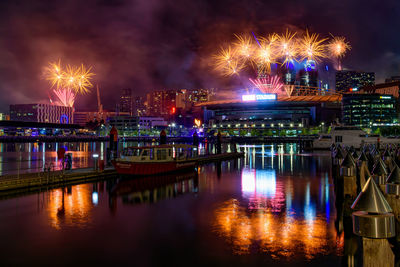 Firework display over river at night