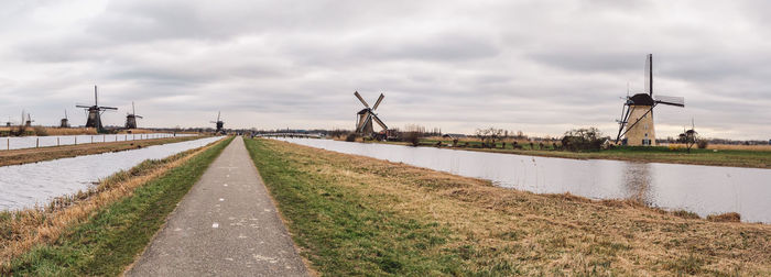 Panoramic view of road by canal against sky