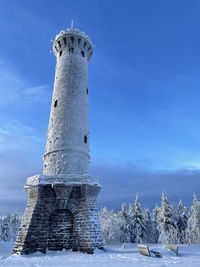 Low angle view of lighthouse against sky during winter