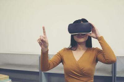 Young woman gesturing while wearing virtual reality simulator