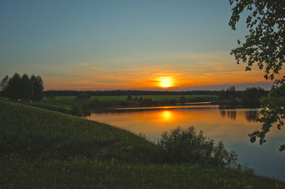 Scenic view of agricultural field against sky during sunset