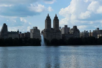 Buildings in city against cloudy sky