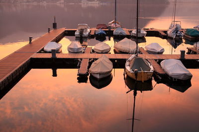 High angle view of boats moored at pier in lake during sunset