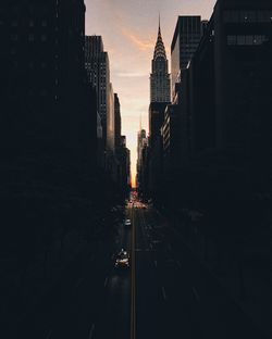 Street amidst buildings in city during sunset