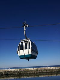 Low angle view of clothes hanging against clear blue sky