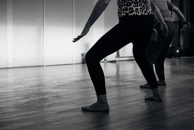 Low section of women dancing on hardwood floor at studio