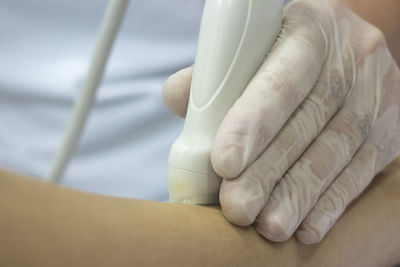 Close-up of doctor holding monitoring equipment on patient