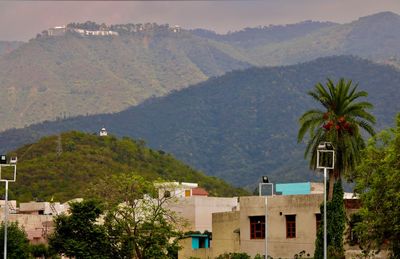 Scenic view of townscape and mountains against sky