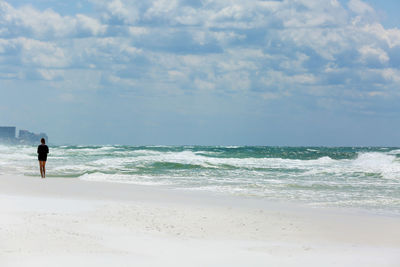 Woman standing on beach against sky