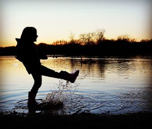 Silhouette of people at lakeshore during sunset