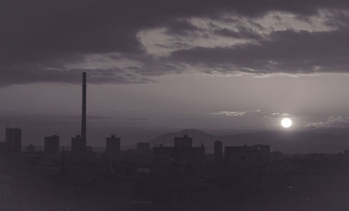 View of cityscape against cloudy sky