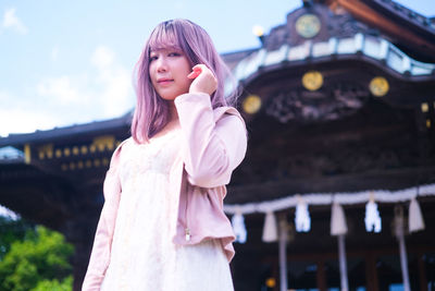 Portrait of japanese young woman standing in shrine