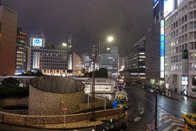 Illuminated cityscape against sky at night