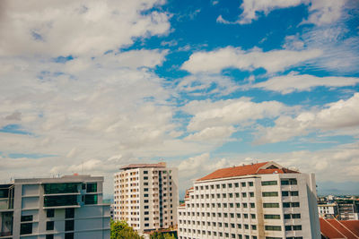 Low angle view of buildings against cloudy sky