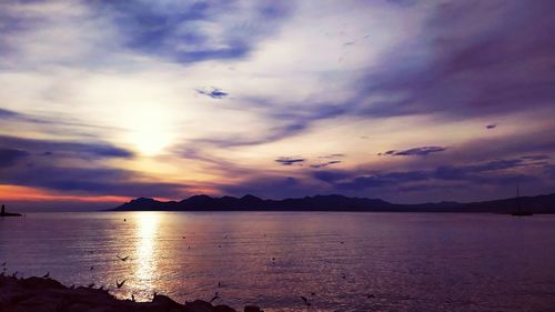 Scenic view of sea against dramatic sky during sunset