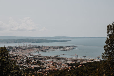 High angle view of townscape by sea against sky