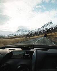 Car on snow covered mountains against sky