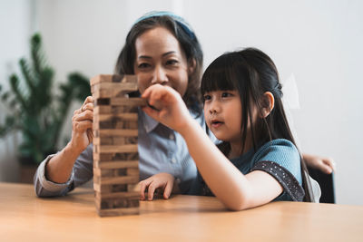Mother and daughter playing jenga at home