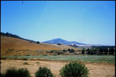 Scenic view of landscape and mountains against clear blue sky