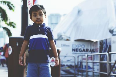 Portrait of boy standing in city